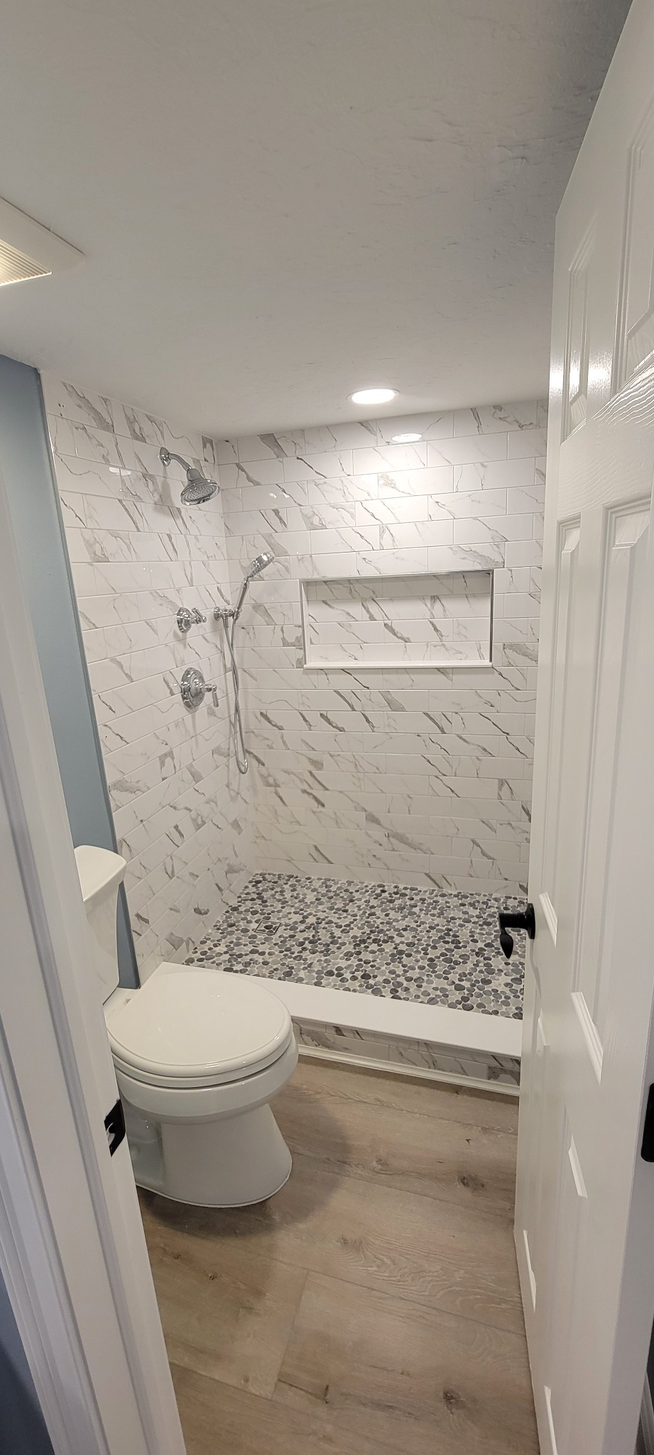 Completed bathroom with tiled walk-in shower and pebble mosaic floor
