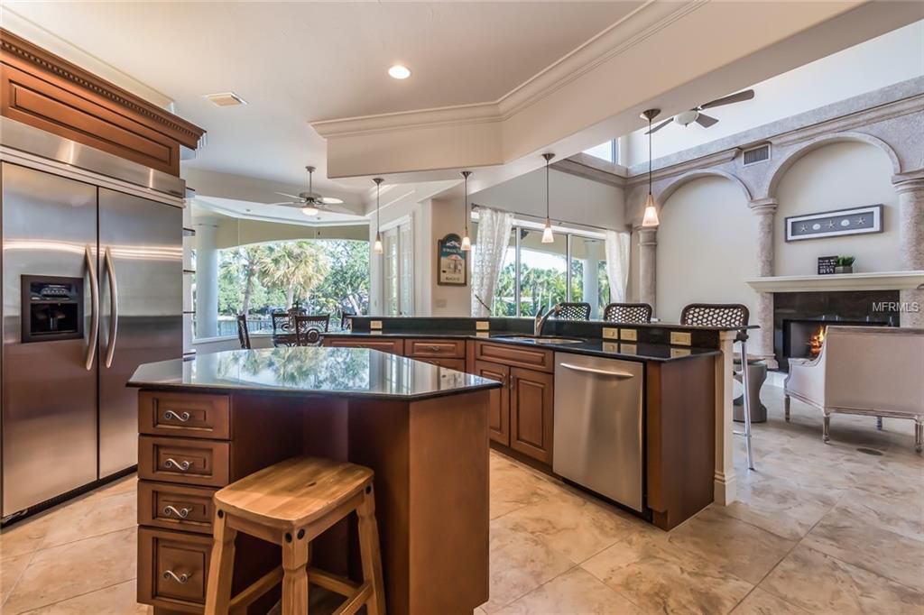 Kitchen before renovation with dark wood cabinetry and black countertops
