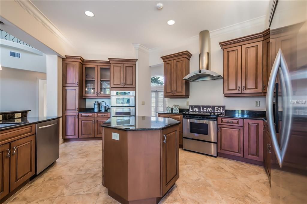 Kitchen before renovation showing dark cabinetry and center island