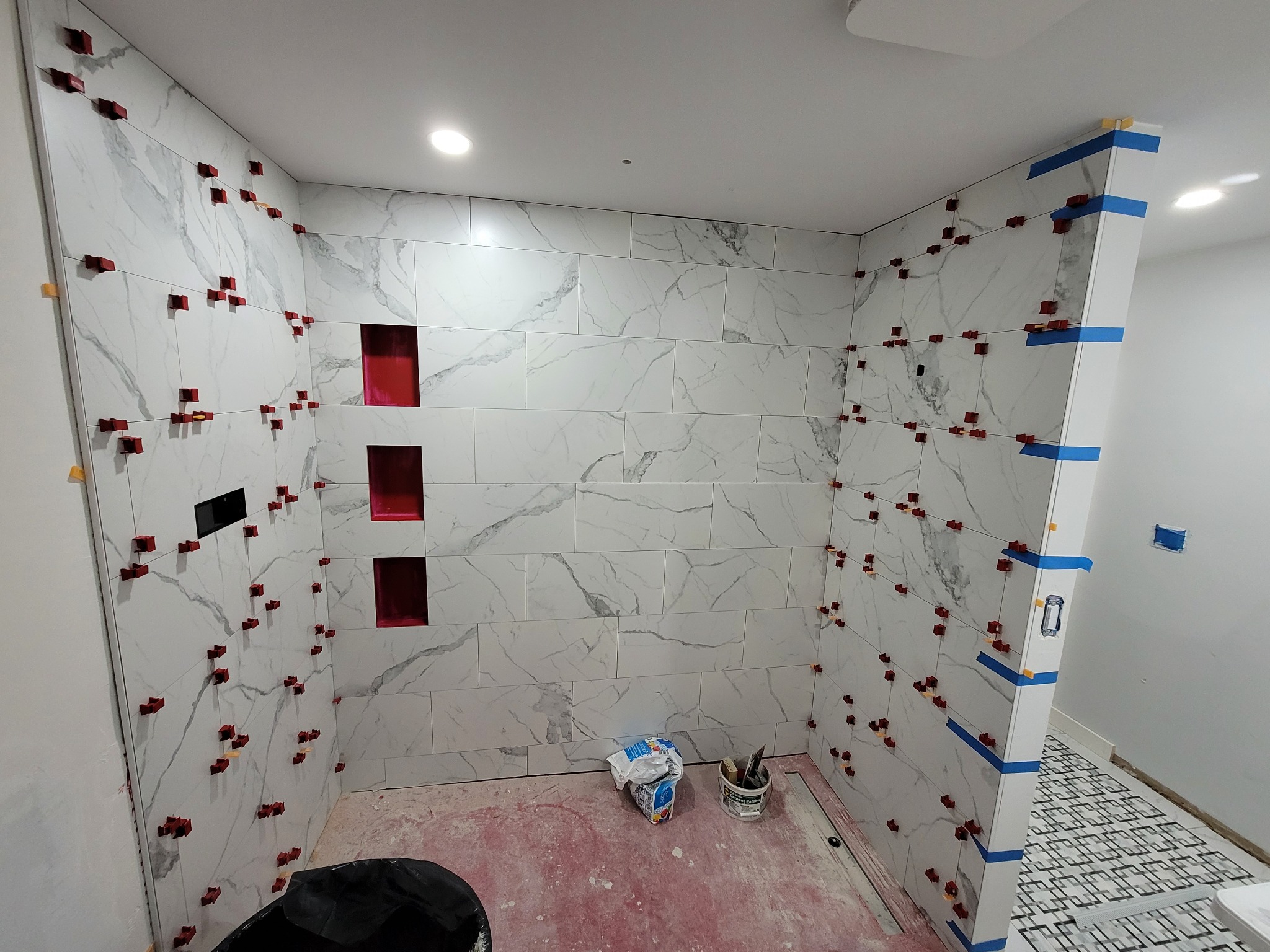 Large format shower tile installation in progress